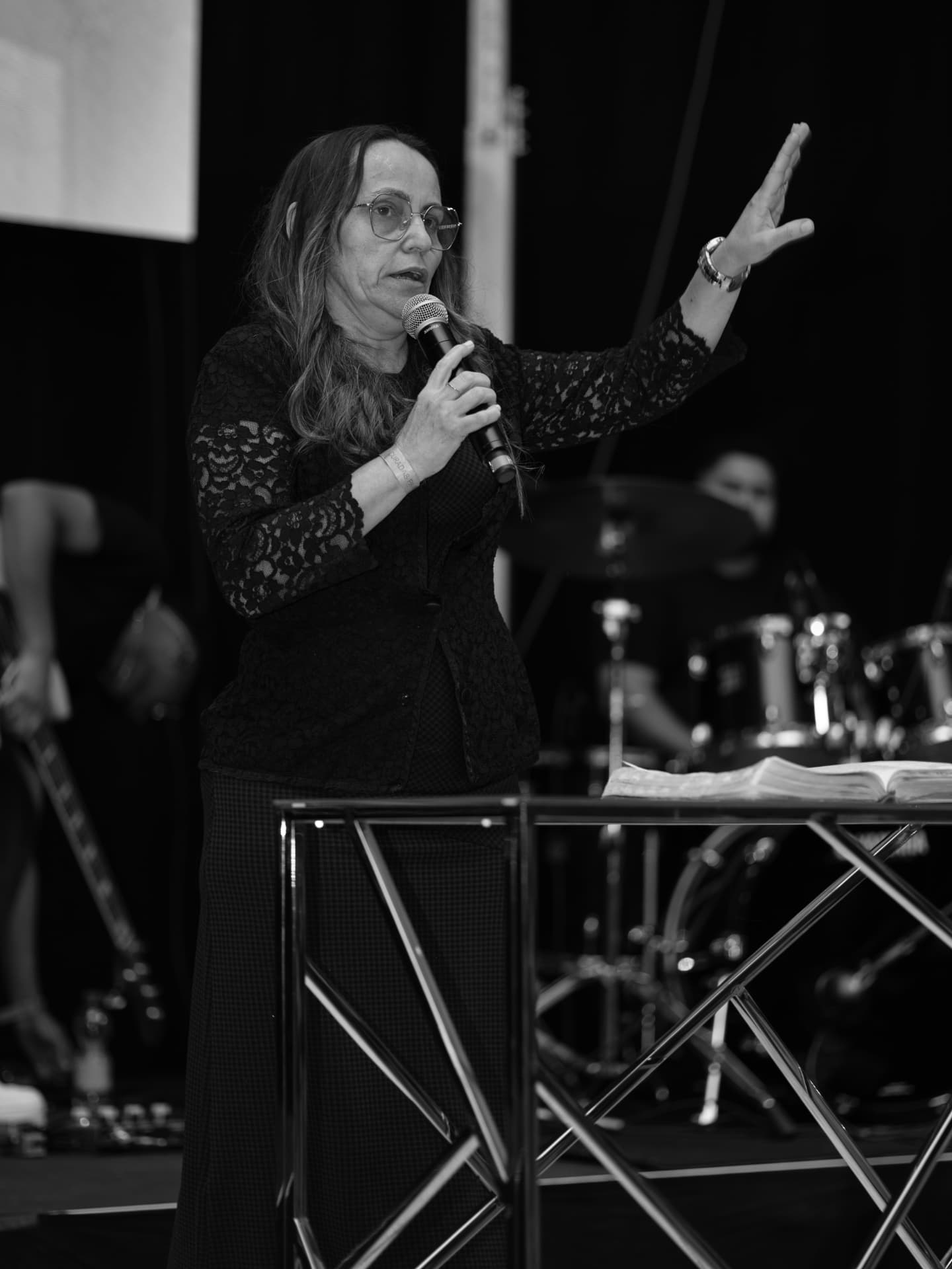 Miss. Edislene ministrando com microfone e Bíblia em um encontro do Curadas